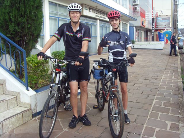 Pai e filho de bicicleta na estrada